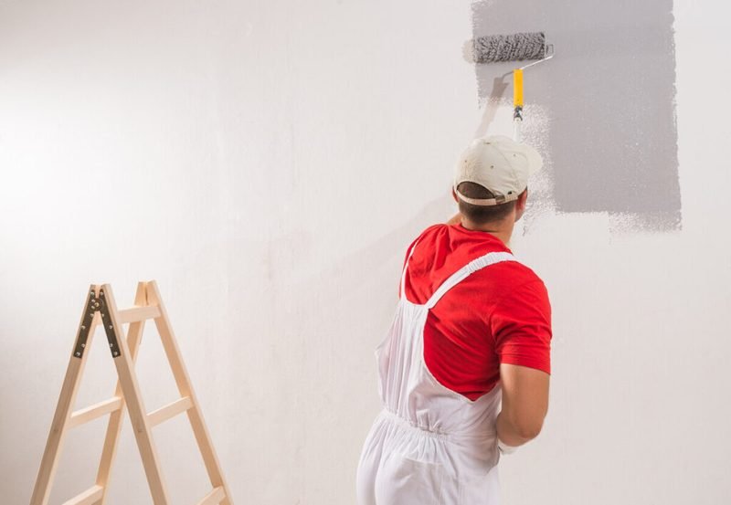 Painter rolling fresh paint onto an interior wall